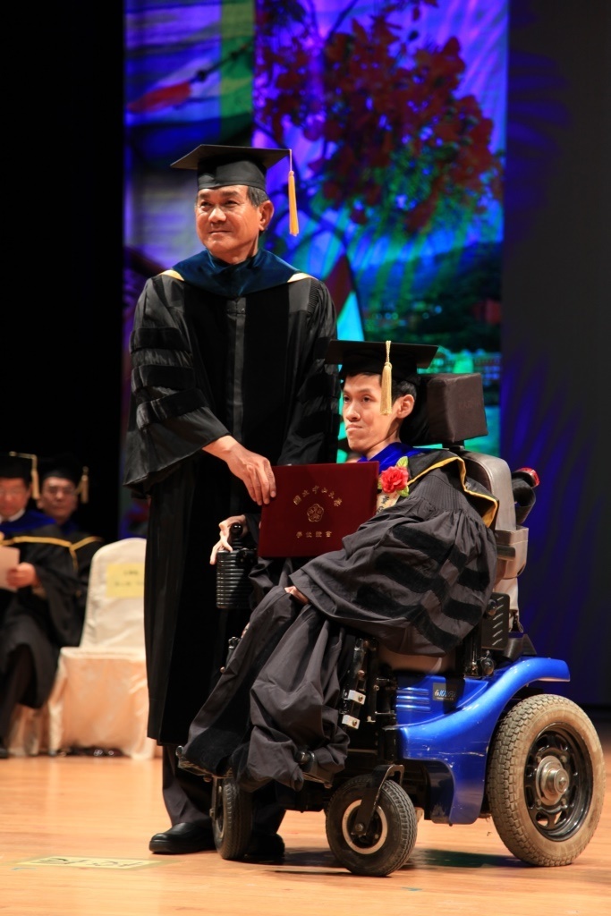 中山大學畢業生董庭吉（右）從小罹患脊髓型肌萎縮症，他以無比堅定的意志力，7日獲得資訊工程學系博士學位，還於前年通過高考，他的努力與成就獲得最多的喝采與掌聲。中央社記者王淑芬攝 103年6月7日(另開新視窗/jpg檔)圖片
