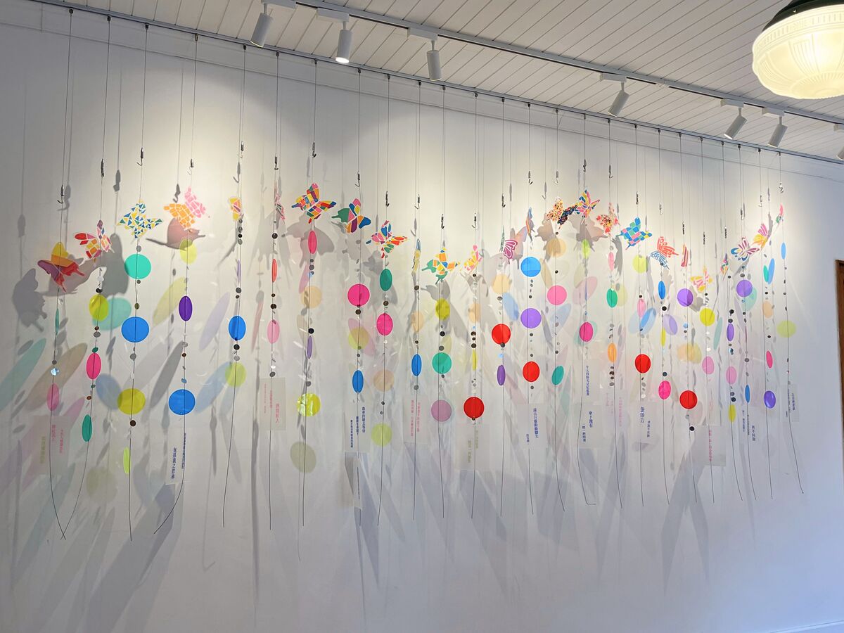 南嶼詩社展現春天的〈複色光〉，由多彩圓片與藤蔓構成，蝴蝶在牆面與光影間穿梭，形成柔和明朗的春日印象。(另開新視窗/jpg檔)圖片