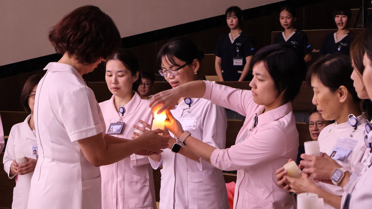 傳光儀式中，由護理系郭素娥系主任傳光予教師群(另開新視窗/jpg檔)圖片