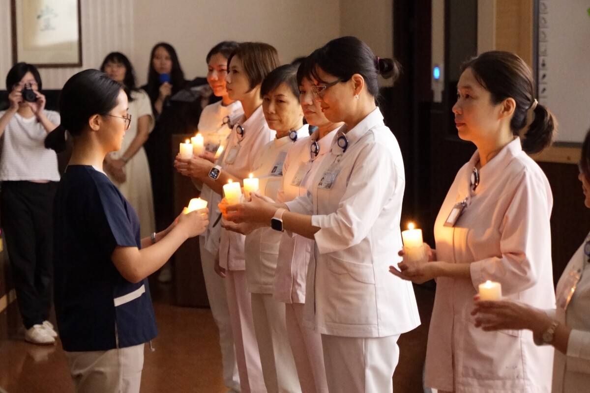 傳光儀式中，再由學生事務委員會主委王俞蓉助理教授傳光給學生代表黃敏(另開新視窗/jpg檔)圖片