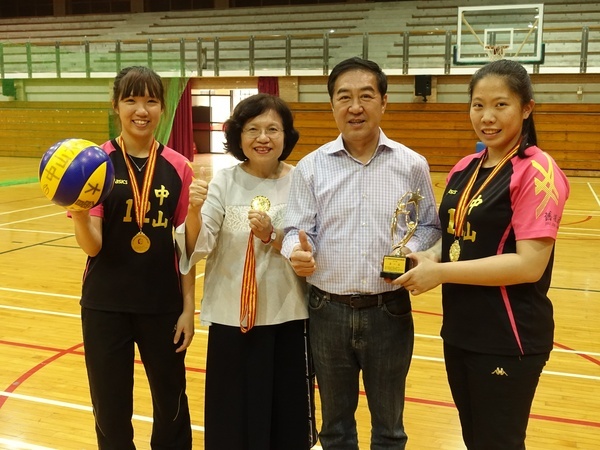 中山大學女排成員楊子琳(左一)與簡鸝樺(右一)參加兩岸四地比賽摘金，獻獎給副校長蔡秀芬(左二)及舊振南食品公司董事長李雄慶(左三)。(另開新視窗/jpg檔)圖片