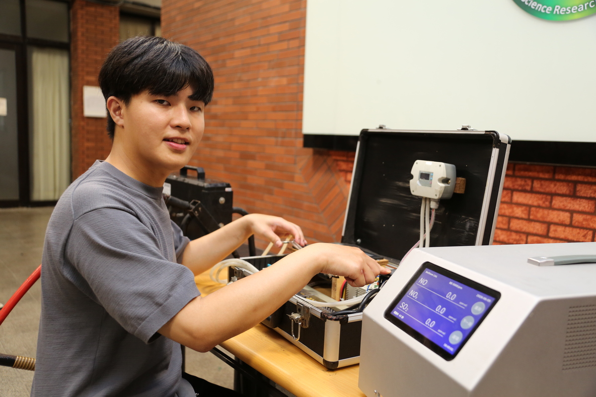 論文第一作者、國立中山大學環境工程研究所博士生簡伯諺說明攜帶至船舶靠泊運轉期間進行採樣與即時監測的設備。(另開新視窗/jpg檔)圖片