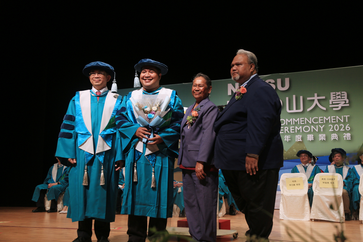 中山大學首位即將畢業的帛琉籍博士生艾博內（左二），獲帛琉共和國駐台代辦歐儒侃（右一）親自到場獻花祝賀。(另開新視窗/jpg檔)圖片