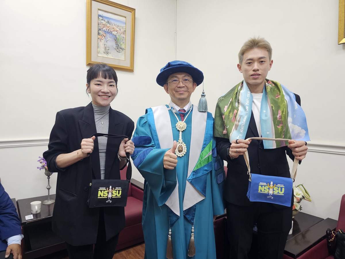 國立中山大學校長李志鵬（中）致贈羽球國手林俊易（右）及甫新婚的夫人程郁捷中山大學小書包與運動毛巾，以及出國實用的行李束帶與吊牌，祝福比賽順利。(另開新視窗/jpg檔)圖片
