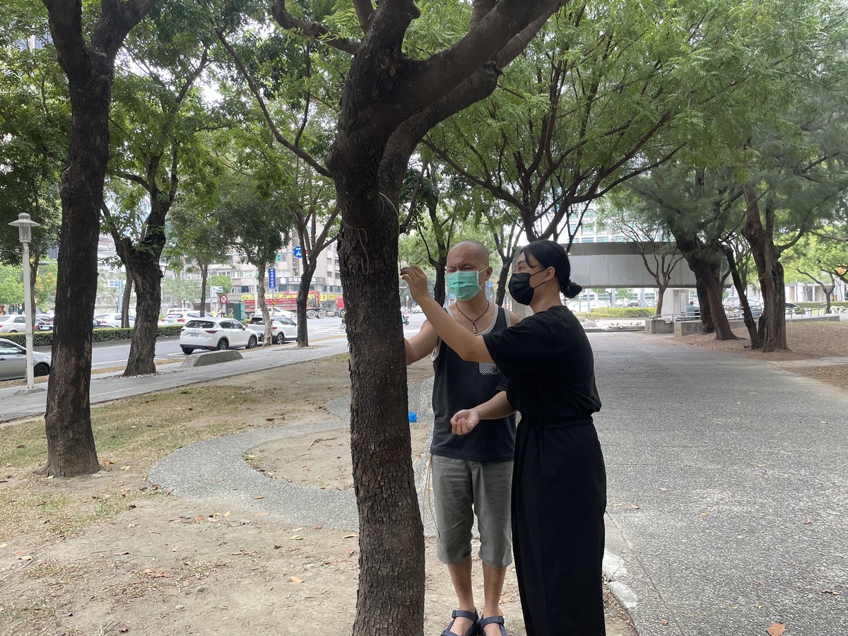 中山大學學生與視障學員在中央公園以觸摸方式探索樹幹質地(另開新視窗/jpeg檔)