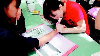 中山大學僑外週活動推出各式美食與文化體驗，印度彩繪的美麗圖案，吸引不少學生嘗試。 記者蔡容喬／攝影(另開新視窗/jpg檔)圖片