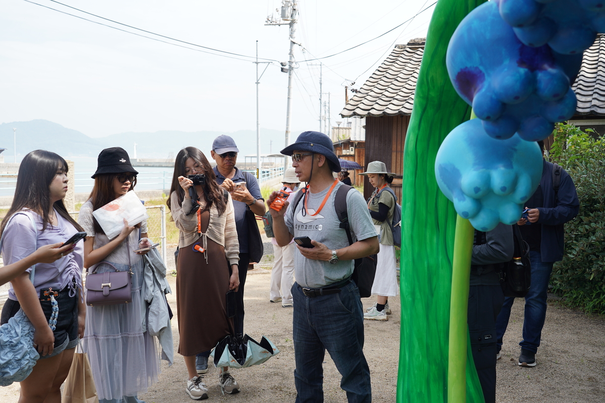 中山公事所郭瑞坤教授解說犬島上的藝術品「Flower Fairy Dancers」。(另開新視窗/jpg檔)圖片