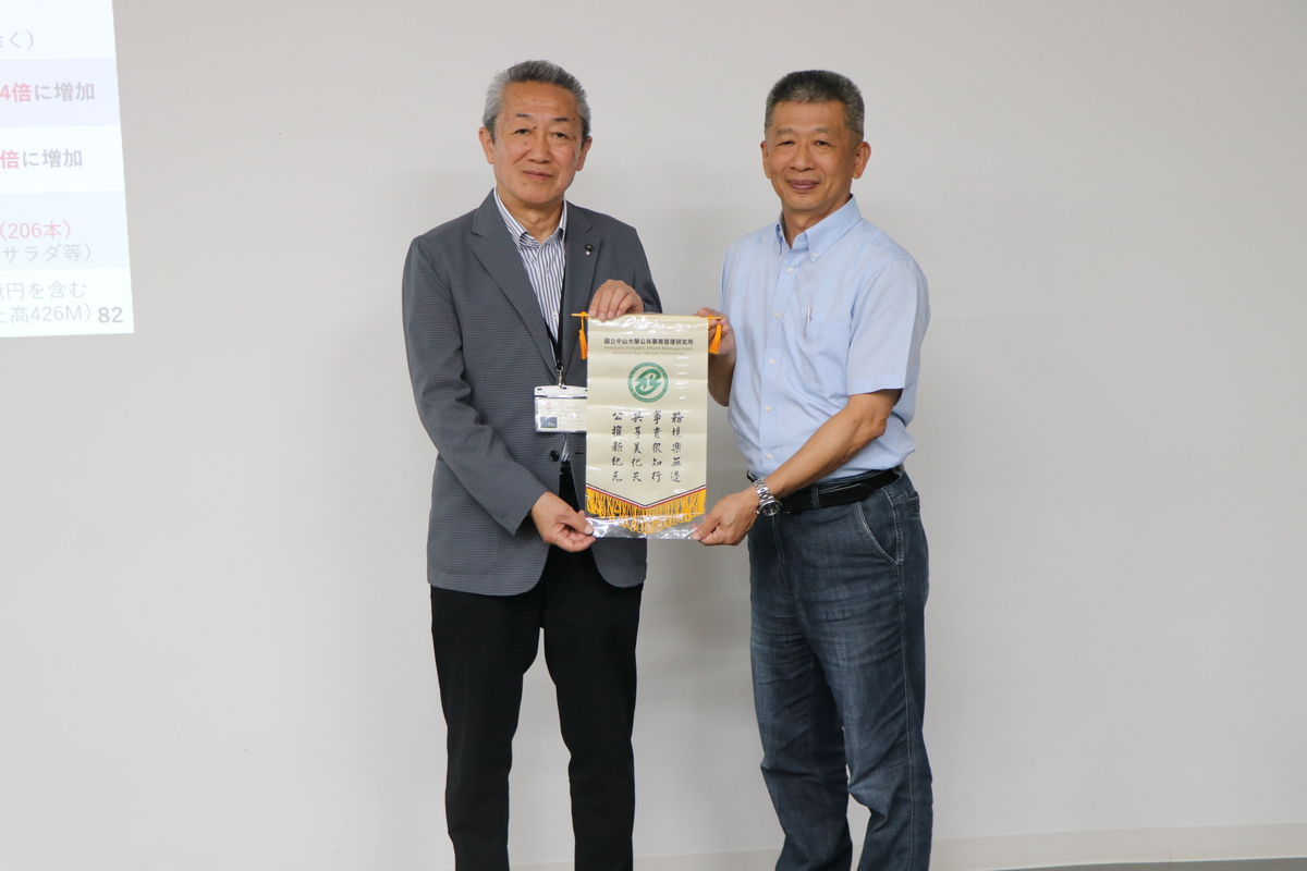 中山大學公事所郭瑞坤教授致贈錦旗予大洲市地域振興聯盟理事長，並與理事長相互交流有關於城下町活化和歷史建築再利用之經驗。(另開新視窗/jpg檔)圖片