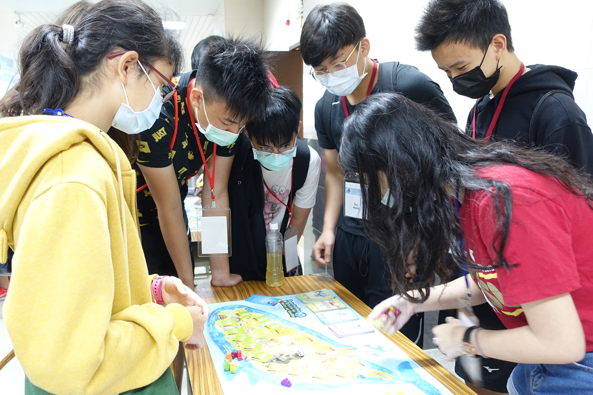 現場亦準備了空污主題桌遊讓學生體驗,國際學生在氣膠科學研究中心環境教育推廣組組長、教育所教授謝百淇的指導下,玩「守護蓋亞˙空品保衛戰」桌遊。