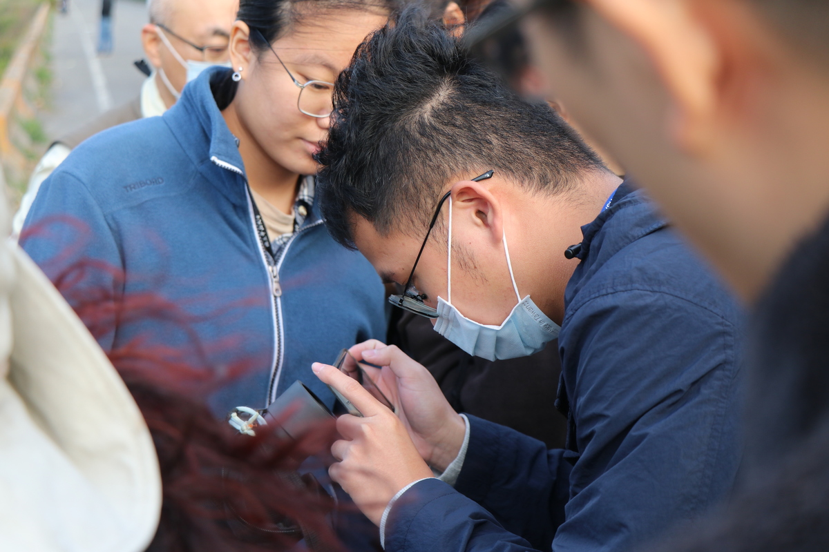 學生專注紀錄望遠鏡中的黑面琵鷺。