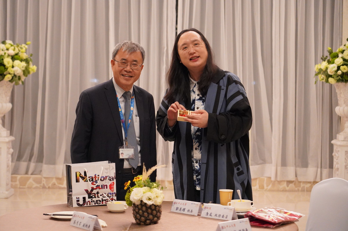 國立中山大學邀請行政院政務委員唐鳳(右)蒞校分享「台灣社會創新發展趨勢」,校長鄭英耀(左)致贈「牛鈴」紀念品。圖/西灣學院提供